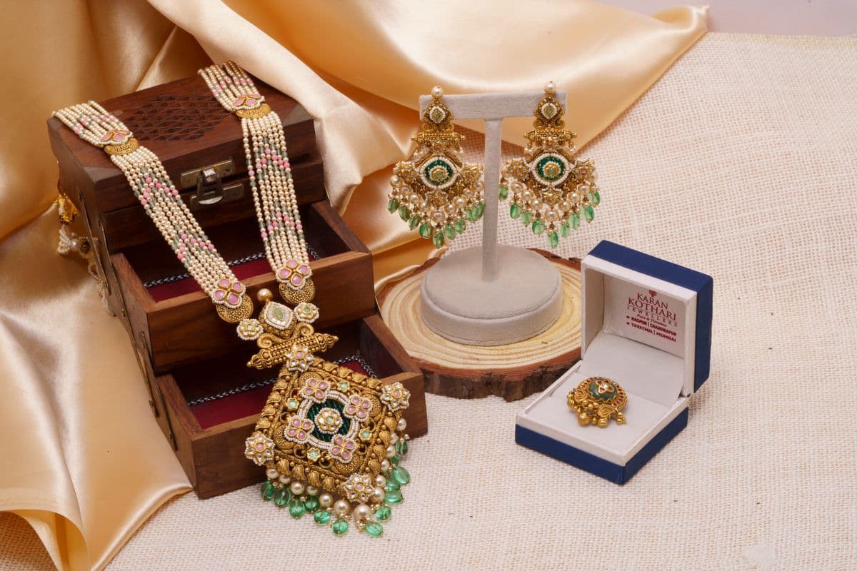 Pearl and emerald Indian necklace, earrings and ring arranged as a still life