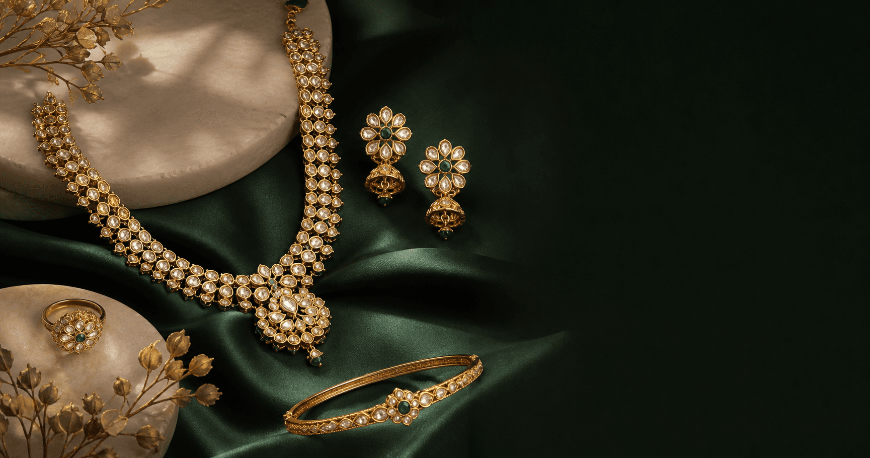 Kundan-inspired gold, diamond and emerald jewelry arranged on deep green silk